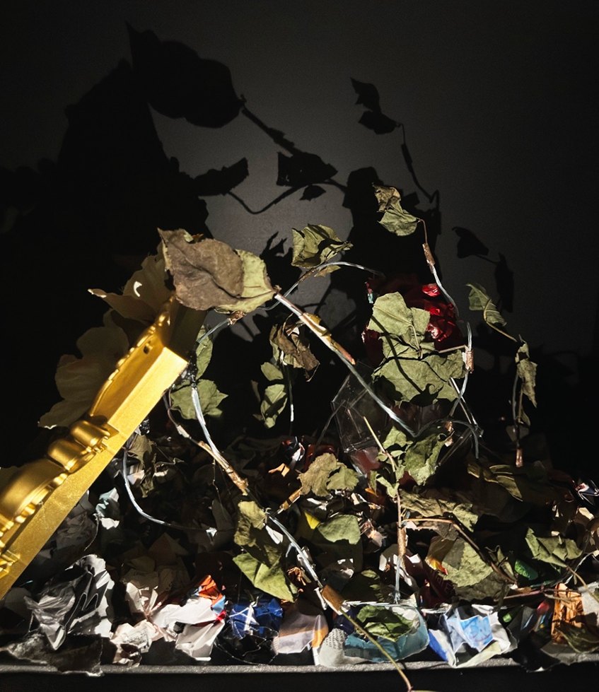 Tainted, detail in low light: leaves trailing over the edge of the gilded frame