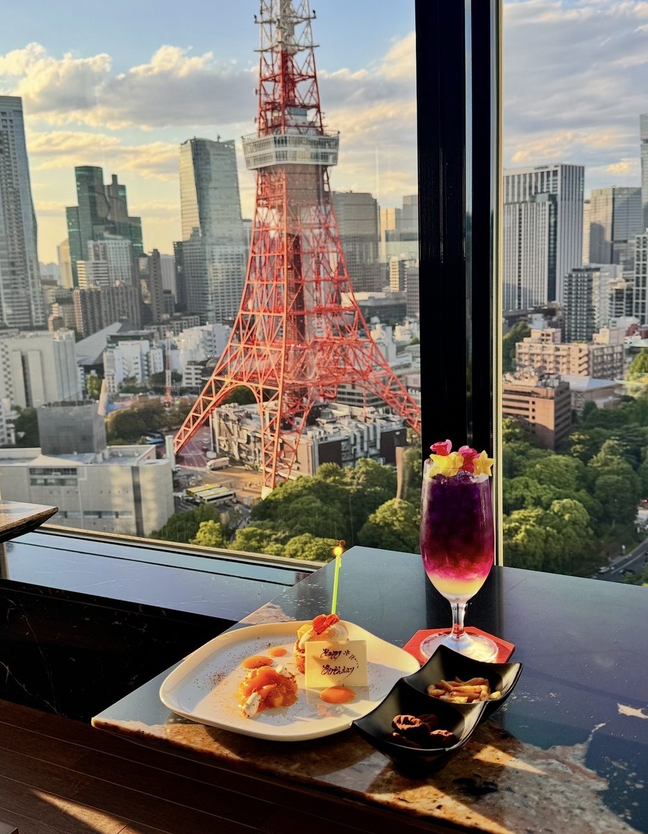 Tokyo Tower seen from a café table with a drink and dessert