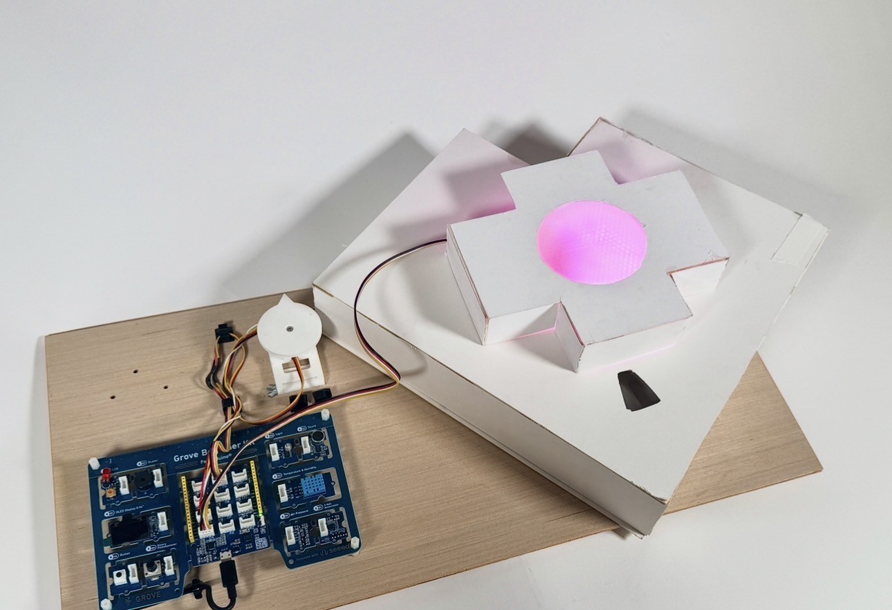 The Med-A pill dispenser on its wooden base, its centre glowing pink