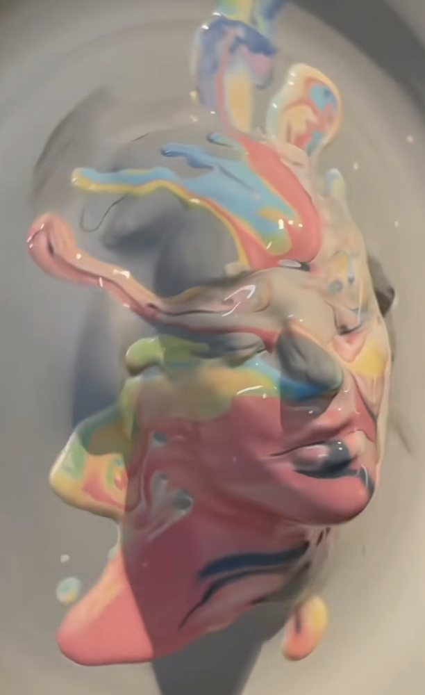 A face formed from swirling coloured paint