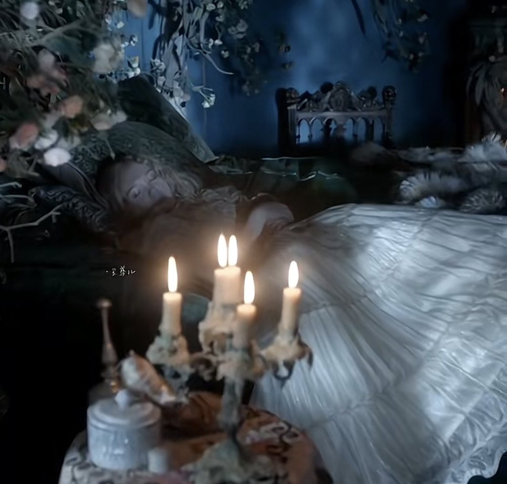 Candles on a candelabra beside a white gown in a dark garden