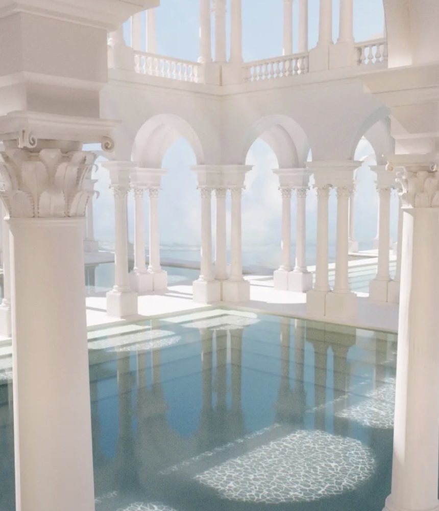 A white colonnade around a still pool